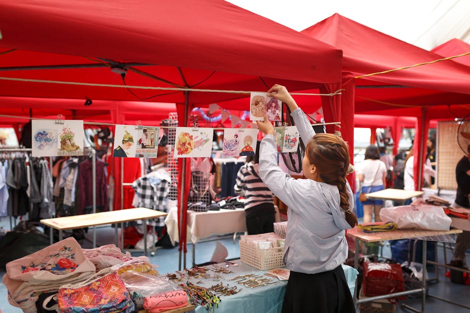 Vibrant marketplace with red tents, shoppers, and colorful goods on display.